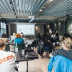 A diverse group attending an educational workshop indoors, focused on a presentation.